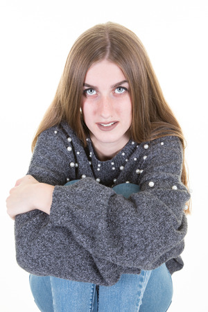 confident portrait of young woman with arms crossed on legs isolated on white background in studioの写真素材