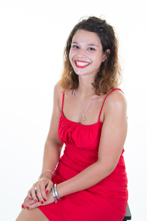 friendly smiling young woman portrait studio shot in red dressの写真素材
