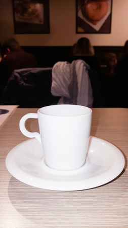 side view of white coffee cup in wooden tableの写真素材