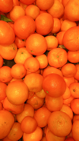Big bunch of ripe tangerines oranges as the background on market stallの写真素材