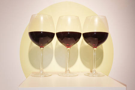 three glasses balloons half filled with wine on retro fashion trend backgroundの写真素材