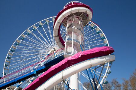 colorful Ferris wheel against a clear blue sky big wheel carousel with white pink giant slide