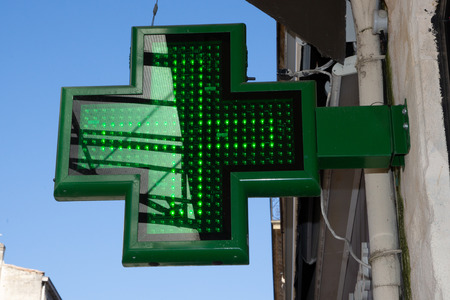 green pharmacy sign outside a pharmacy store in streetの写真素材