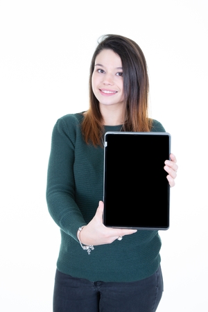 Cheerful young woman holding blank screen tabletの写真素材