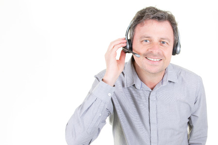 handsome young man in work in call-centre with headphones on white background with copy spaceの写真素材