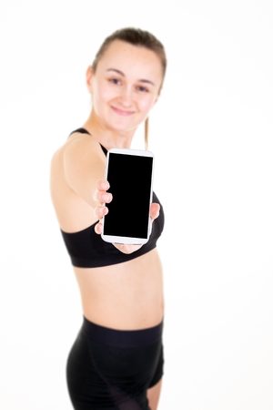 sporty fitness happy young fit woman showing blank screen mobile phoneの写真素材