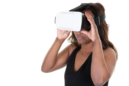 Studio shot of african american woman wearing virtual reality goggles watching movies playing video...