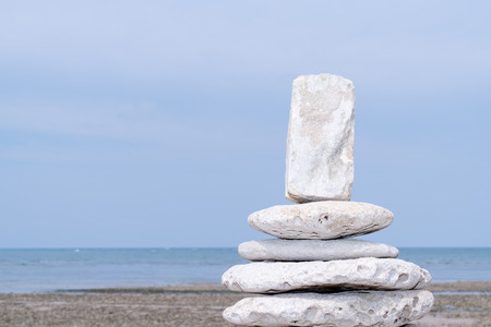 Pyramid of stones standing in beach water real natural blurred backgroundの写真素材