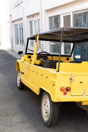yellow vintage summer car in street in vacation