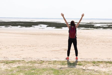 woman rejoicing against ocean landscape in summer