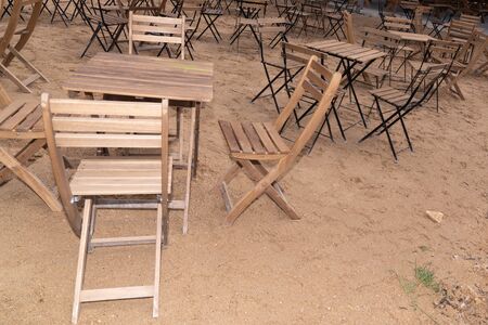 wooden table place and chairs on sandy beach