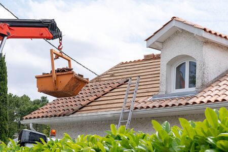 change of tiles on roof of house with high dump on building site