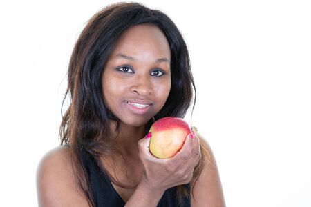 Beautiful Afro-American girl eating red appleの写真素材