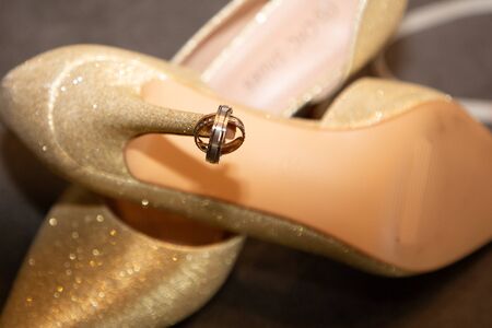 Golden wedding rings on bride shoes symbol of love and marriage