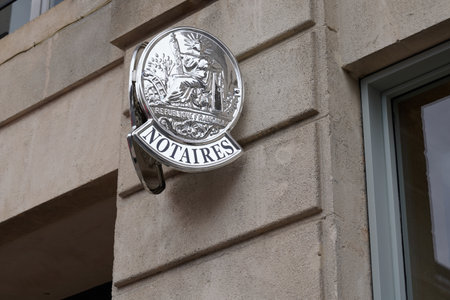 Notaire sign silver on wall above entrance to the notary office