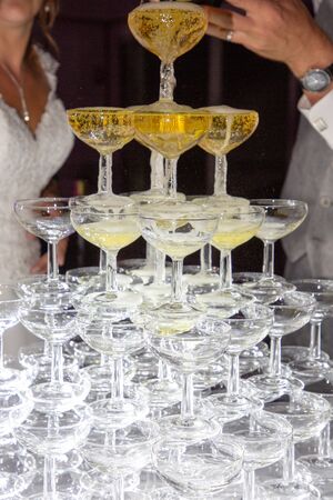 champagne glasses standing in pyramid tower at wedding bride groom partyの写真素材