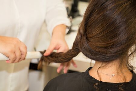 Portrait of beautiful young woman getting haircut braid of hair