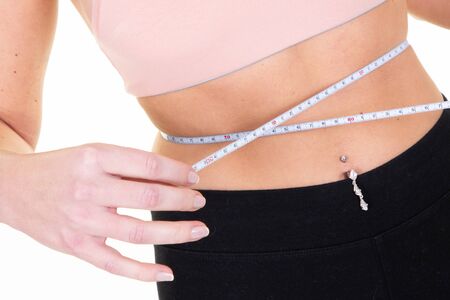 slender slim sporty woman measuring waist line weight lossの写真素材