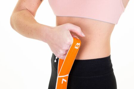 Young pretty slim woman sporty doing stretching exercises with elastic bands rubber band wearing...