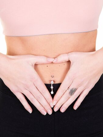 woman shows two hands gesture heart on slim stomach on white background Concept girl health first...
