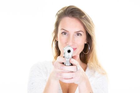 Portrait of an attractive blonde woman silver gun in handsの写真素材