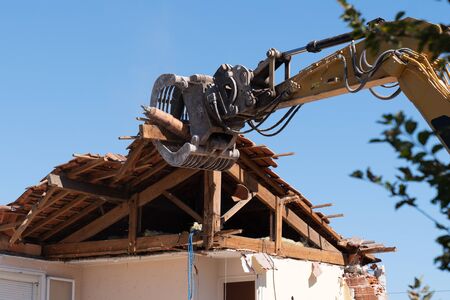 industrial excavator working demolition of house old residential buildingの写真素材