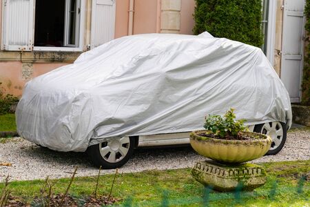 small car with grey silver cover in the streetの写真素材