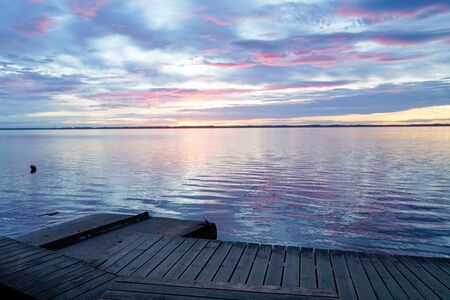 Biscarrosse lake at sunset with wooden boat pontoon jetty in franceの写真素材
