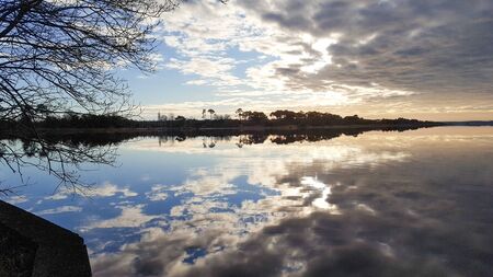 sunset sky cloud sun reflection in Biscarrosse lake sunrise France landesの写真素材