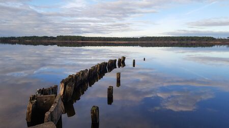 reflection of the sky and clouds in the waters of the lake breakwater breaking the waves access port harbor Biscarrosse Franceの写真素材