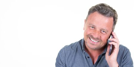 happy handsome man over isolated white background call a conversation with smartphone mobile phoneの写真素材