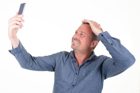 Happy handsome man taking a selfie photo hand on hairs isolated on white background