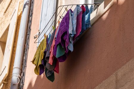 laundry hanging outside a window to dry in the wind in a colorful houseの写真素材