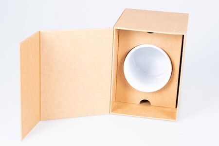 White mug in open carton box on a white background