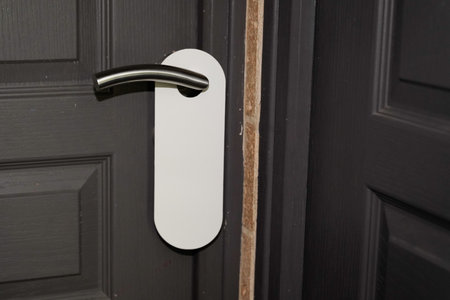 White door hanger on grey classic door with empty label do not disturb realのeditorial素材