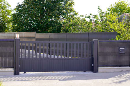 dark gray gate aluminum portal with blades suburbs house street