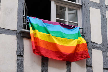 Rainbow colored flag on home windows building on a street in lgbt gay lesbian colorsの写真素材