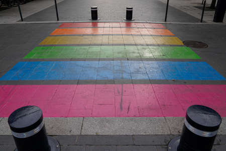 Pedestrian colors crossing street marking in LGBT colorful rainbow floor of lesbian gay flag in...