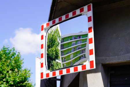 street traffic red white convex mirror in road safety concept in city centerの写真素材