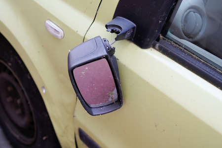 Close-up view of exterior broken vandalism side view mirror on old car