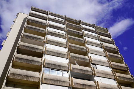 Facade of apartment building on a sunny day with a blue cloudy skyの写真素材