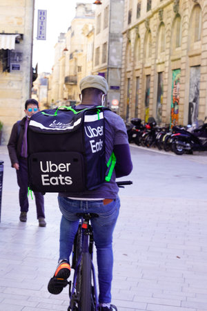 Bordeaux, Aquitaine / France - 11 01 2020: Ubereats delivery man on bike cycle deliver take away...