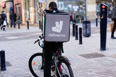Bordeaux, Aquitaine / France - 11 11 2020: Deliveroo logo and text sign on back bag cargo box man delivery on bikeのeditorial素材