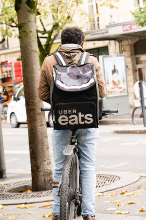 Bordeaux, Aquitaine / France - 11 11 2020: Uber eats man on bike delivery with logo sign brand backpack Ubereats deliver from restaurantのeditorial素材