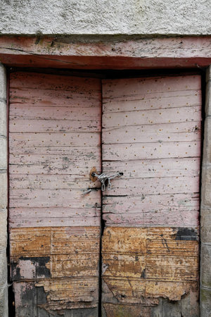 Ancient wooden door in old stone house in vintage village streetの写真素材