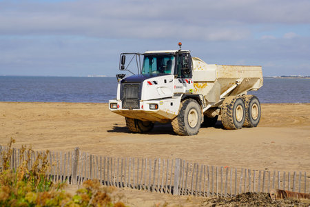 Bordeaux, Aquitaine France - 01 10 2021: Eiffage dump truck tipper industrial vehicle on sand beach...
