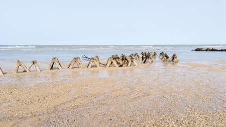 concrete blocks cement breakwater to protect sand beach from storm wavesの写真素材