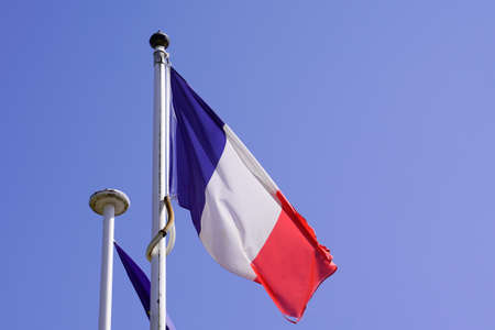 French flag of France wave over a blue cloud sky red blue white colorsの写真素材