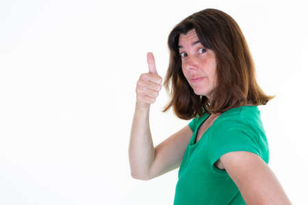 woman brunette giving thumbs up in green shirt on a white background