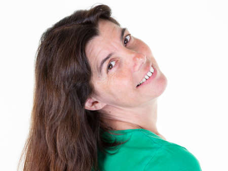 pretty middle aged woman smile positively at camera poses photographer against white backgroundの写真素材